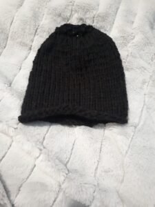 Toddler sized messy bun hat in black acrylic yarn